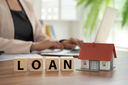 loan with home model on desk with banker Loan approval and mortgage or cash advance concept.